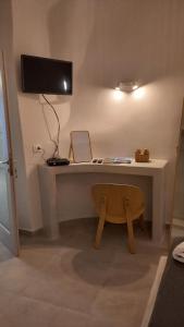 a desk with a monitor and a chair in a room at Cueva House in Vóthon
