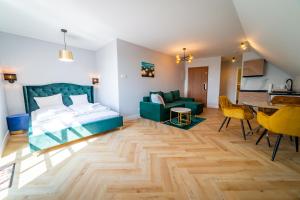 a bedroom with a bed and a dining room at Apartamenty Mazurskie in Mikołajki