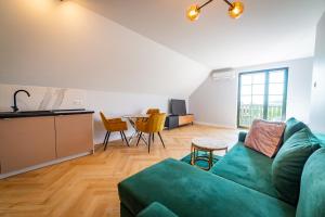 - un salon avec un canapé vert et une table dans l'établissement Apartamenty Mazurskie, à Mikołajki