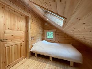 um quarto com uma cama num chalé de madeira em 【moi】山中湖 新築フィンランドログハウス 大自然の中でBBQ可 em Yamanakako