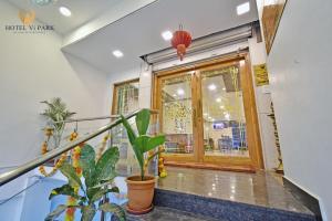 a lobby with a door and a potted plant at Hotel Vi Park - City Centre in Puducherry