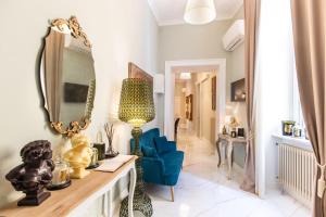 een woonkamer met een blauwe stoel en een spiegel bij Macchiato Suites Boutique Guest House in Napels