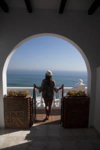 a woman walking through an archway with the ocean in the background at Hostal Mar de Frente in Los Caños de Meca