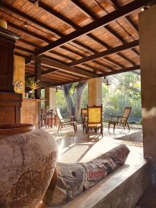 a porch with chairs and a bed on a patio at Dunes Unawatuna Hotel in Unawatuna