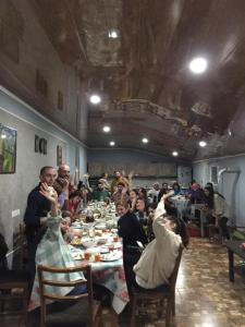 um grupo de pessoas sentadas em torno de uma longa mesa em Mamuka's Guesthouse em Udabno