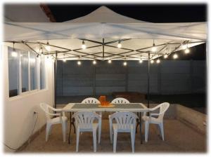 a table and chairs under a white tent with lights at Casa Oliveros in Sunampe