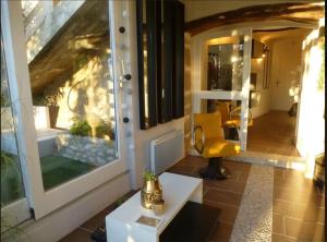 a living room with a yellow chair and a table at La vue sur le Mont Ventoux, appartement & parking in Cairanne