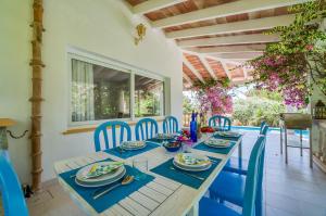 Un comedor con una mesa y sillas azules. en Ideal Property Mallorca - Casa Bonita, en Colonia de Campos