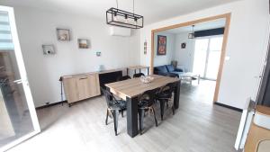 a kitchen and dining room with a table and chairs at Maison avec jardin, quartier calme, 2 chambres - plain pied in Saint-Hilaire-de-Riez
