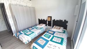 two twin beds in a room withthritisthritisthritisthritisthritisthritisthritisthritisthritis at Maison avec jardin, quartier calme, 2 chambres - plain pied in Saint-Hilaire-de-Riez