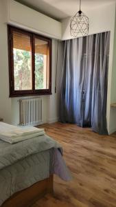 um quarto com uma cama e uma grande janela em Aretina Florence Villa em Florença