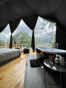 a bedroom with a bed and a large glass wall at Elia Glamping in Stepantsminda