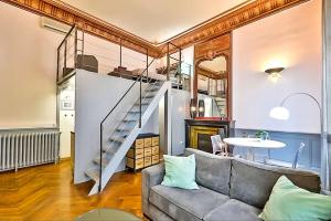 a living room with a couch and a table and stairs at Appartement Chic & Baroque avec parking sécurisé in Avignon