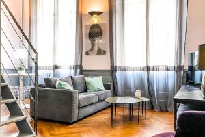 a living room with a couch and a table at Appartement Chic & Baroque avec parking sécurisé in Avignon