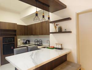 a kitchen with a white counter and wooden cabinets at One Bedroom Troika Kota Bharu by AGhome, Modern Design in Kota Bharu