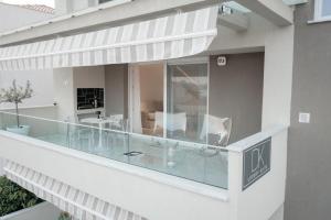 a balcony with glass furniture on a building at DK Luxury Suite in Nea Peramos