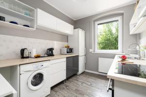 y cocina con lavadora y secadora. en Spacious Family Apartment Promienista 1,5 km to Hala Arena Poznań by Renters en Poznan