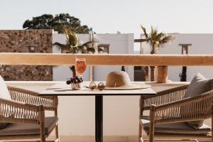 - un chapeau et des lunettes sur une table sur un balcon dans l'établissement Myra Hotel, à Kavala