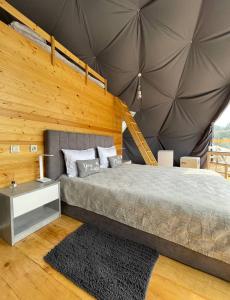 a bedroom with a bed and a wooden wall at Elia Glamping in Stepantsminda