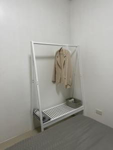 a white rack with a shirt and a coat at Uptown CDO Staycation in Cagayan de Oro