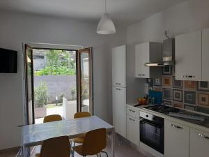uma cozinha com mesa e cadeiras e uma janela em Casa Vacanze Palinuro-Mare em Palinuro