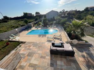 - une piscine avec 2 chaises longues à côté dans l'établissement Villa Héliopolis, à Ventiseri