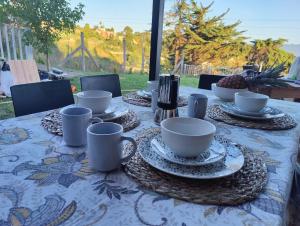 a table with cups and saucers on it at Apartamento mirador a las Islas Cíes in Cangas de Morrazo