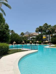 uma piscina com água azul num resort em Apartman La Concha in Puerto Banus em Marbella