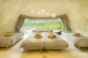 1 Schlafzimmer mit 2 Betten und einem großen Fenster in der Unterkunft Rusutsu Pension Clydesdale in Rusutsu