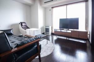 Fancy2 في سابورو: غرفة معيشة مع أريكة وتلفزيون بشاشة مسطحة