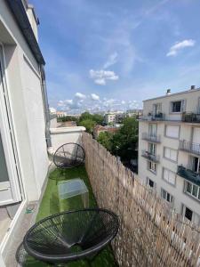 a balcony with two chairs and a table on a building at Appartement studio proche Paris 14, Paris 15 in Malakoff