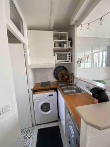 a small kitchen with a sink and a washing machine at Appartement studio proche Paris 14, Paris 15 in Malakoff