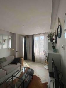 a living room with a couch and a glass table at Appartement studio proche Paris 14, Paris 15 in Malakoff