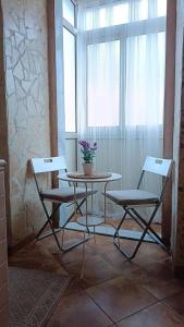 1 mesa y 2 sillas en una habitación con ventana en Vichome en Catania
