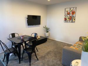 a living room with a table and a tv at 2 Bedroom Unit in Queenstown in Frankton Wharf