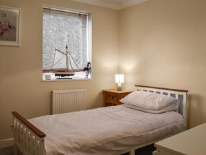 a bedroom with a bed and a window with a sailboat in it at Fayrewood House in Verwood