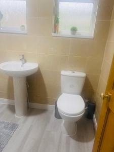 a bathroom with a white toilet and a sink at Wilzly in Tollbar End