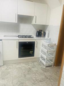 a kitchen with white cabinets and a stove top oven at Wilzly in Tollbar End