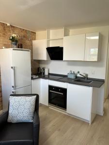 eine Küche mit weißen Schränken und einem schwarzen Gerät in der Unterkunft Villa Holger in Skagen