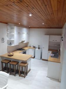 a kitchen with white appliances and a wooden ceiling at JT Surfhouse in Jeffreys Bay +8 photos