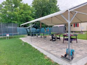 a pavilion with tables and picnic tables in a park at Szárszó Panzió in Balatonszárszó