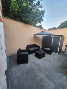 a patio with black furniture and an umbrella at Studio proche gare Vernon Giverny avec parking gratuit in Vernon