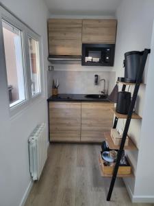 a small kitchen with a stove and a microwave at Studio proche gare Vernon Giverny avec parking gratuit in Vernon