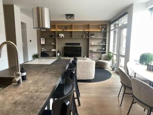 a kitchen with a counter and a living room at Stylish apartment @ city centre in Rotterdam