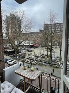 een balkon met een tafel en uitzicht op een park bij Stylish apartment @ city centre in Rotterdam