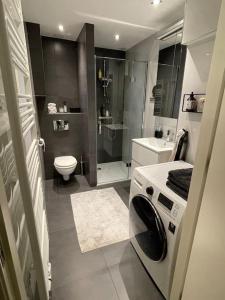 a bathroom with a shower and a washing machine at Stylish apartment @ city centre in Rotterdam