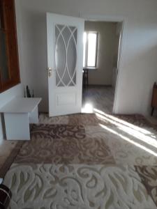 an empty room with a white door and a carpet at Apartment at Narimanov 151 in Ganja