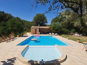 una piscina en un patio con una casa en Mas des rochers - Romance tropicale, en Le Beausset