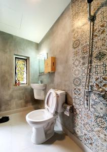 y baño con aseo y ducha. en The Lovenote Home en Ho Chi Minh