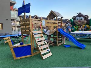 um parque infantil com um escorrega e um conjunto de jogos em Apartment Family Besenova Aquapark em Bešeňová